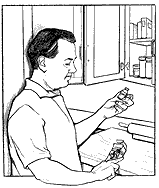 Man looking at a bottle of medicine.